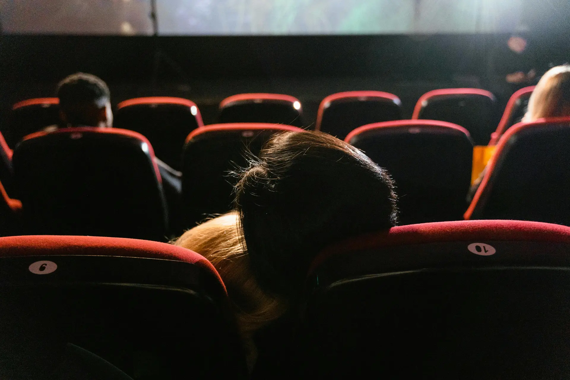 Persone sedute in una sala cinema mentre guardano un film sul grande schermo